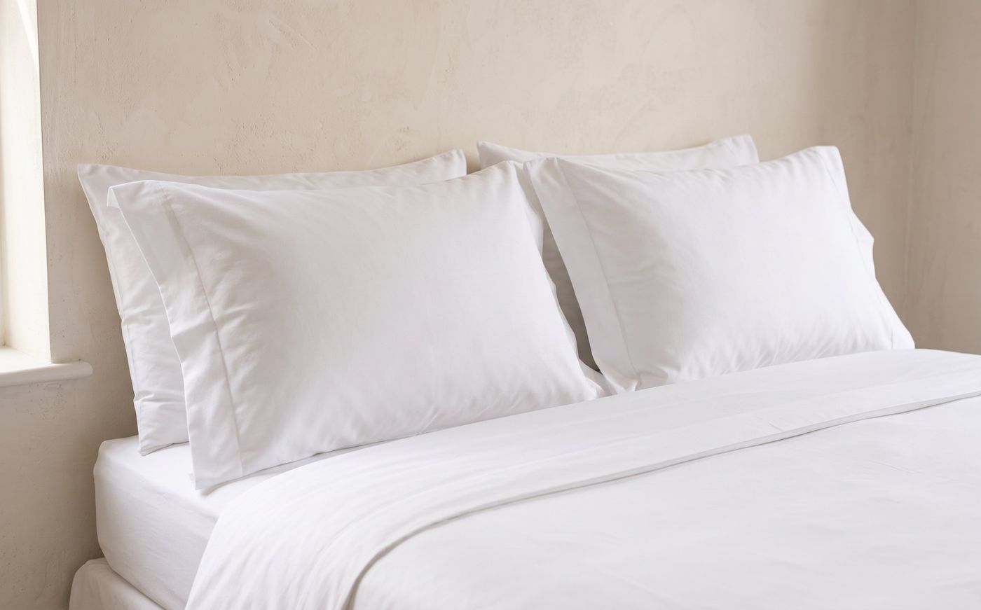 Plump white pillows in pressed Oxford pillowcases